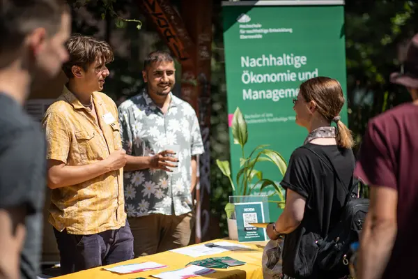 eine Interessierte spricht mit zwei Studierenden