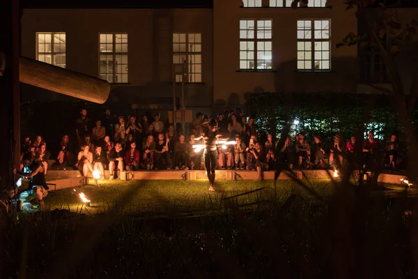 Campusfeast 2024 Eine Frau tanzt mit einem Feuerring um die Hüfte. Viele Menschen sehen zu.
