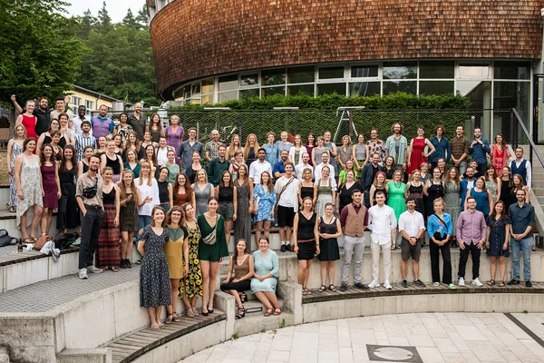 Gruppenfoto der Abschlussfeier 2022 Die Alumni der Hochschule für nachhaltige Entwicklung Eberswalde stehen im Amphitheater auf der Abschlussfeier im Jahr 2022 vor dem Pfeil Auditorium am Waldcampus der HNEE