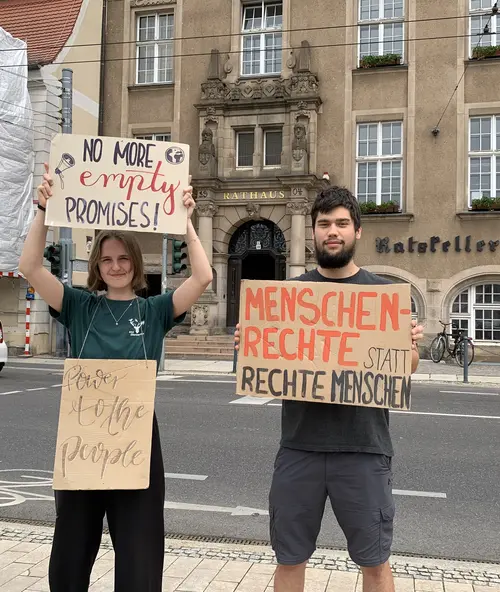 Zwei Aktivist*innen stehen vor dem Eberswalder Rathaus mit mehreren Transparenten für eine klimagerechte Politik! 