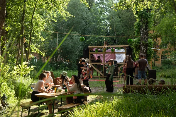 Campusfeast 2024 Menschen sitzen an Tischen und stehen bei Gesprächen zusammen
