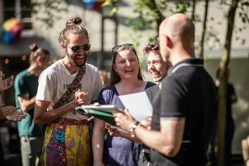 Drei Studierende freuen sich über den Preis, den sie erhalten.