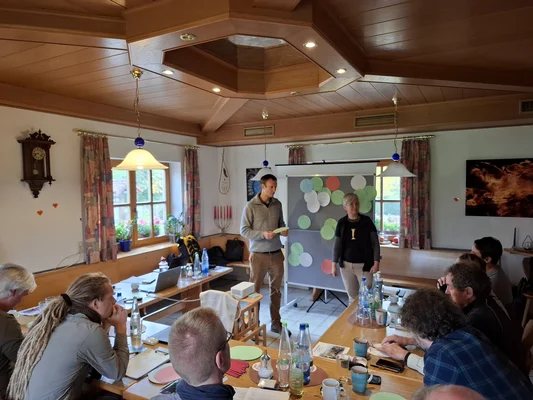 Workshop mit Akteur*innen der Schutzgebietsbetreuung Zwei Personen stellen Ergebnisse der gruppe an einer Pinnwand vor.