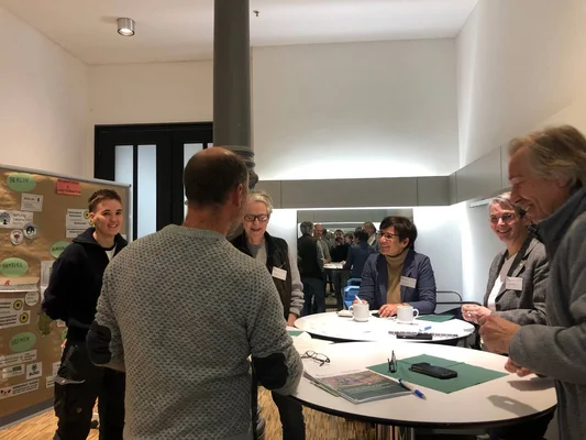 Workshop mit Akteur*innen der Schutzgebietsbetreuung Sechs Personen stehen an einem Stehtisch und unterhalten sich.