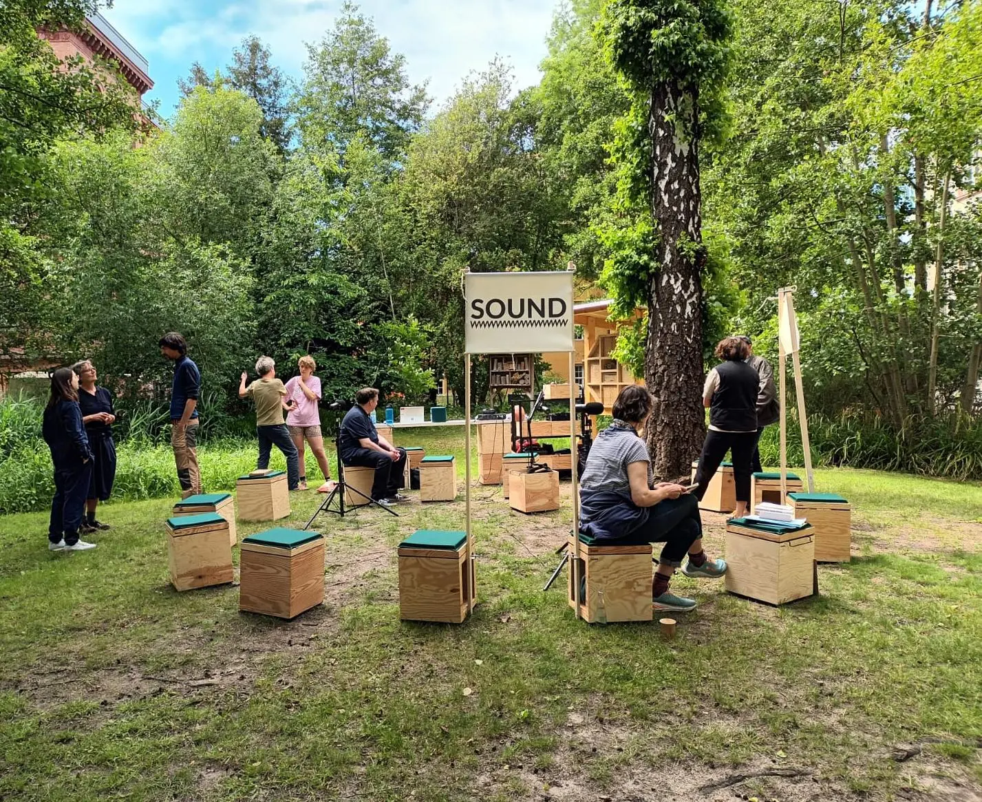 Draußen auf dem Stadtcampus der HNEE sitzen die Teilnehmenden der open academy unter Bäumen